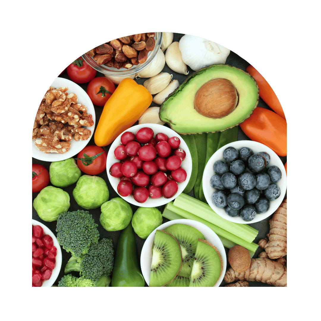 Overhead arrangement of colorful fruits, vegetables, nuts, and bowls on a black background.