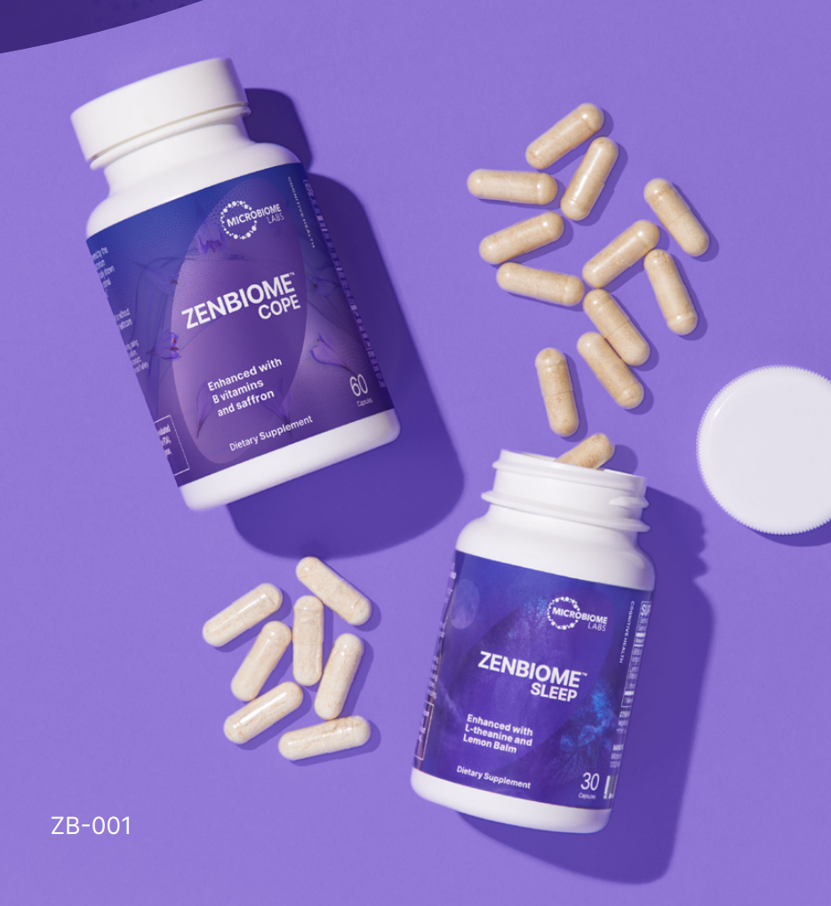 Two Zenbiome supplement bottles, beige capsules, and a white lid on a purple surface.